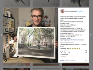 Artist Thierry Duval holding a watercolor painting of a fountain in a city square